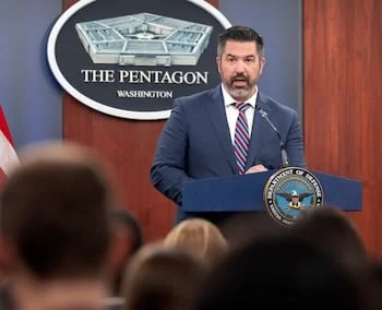 Un hombre con barba oscura y traje azul habla en un podio con el sello del Departamento de Defensa, frente a un logo de "THE PENTAGON"